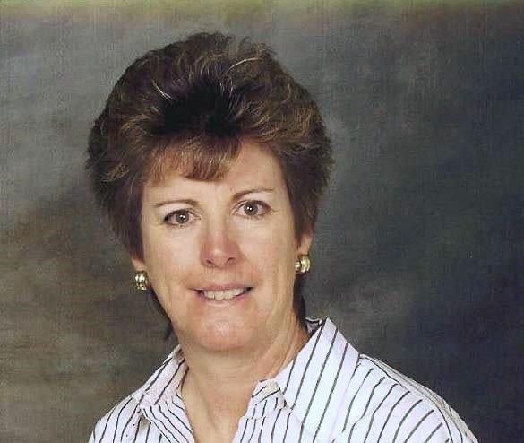 Person wearing gold earrings and a striped shirt with a popped collar, shown against a dark background.